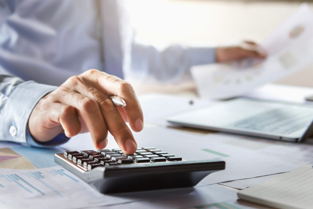 accountant working on desk using calculator for calculate finance report in office